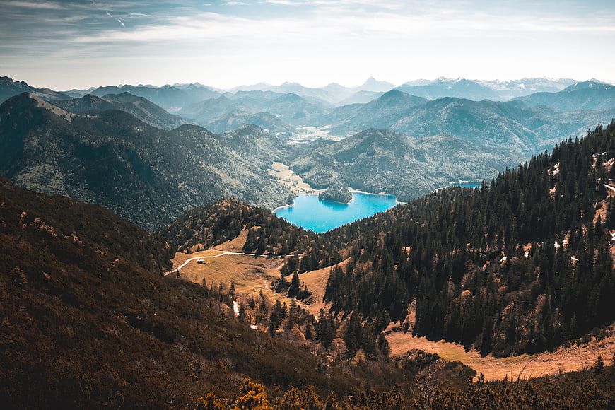 Panoramic Alpine Landscape with Turquoise Lake and Forested Mountains