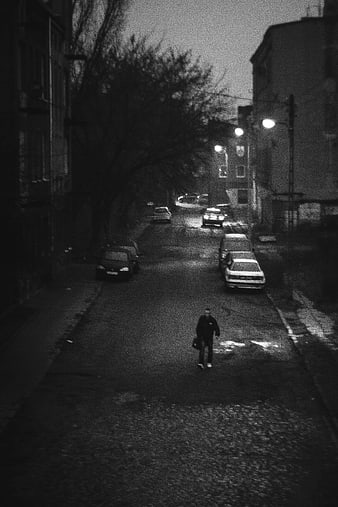Lonely man walking down dark street at night