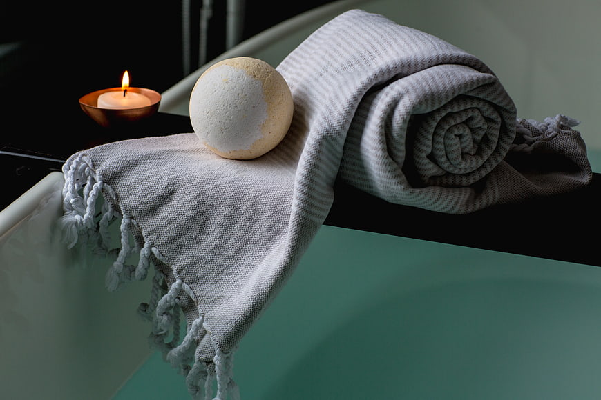 Relaxing Bath Setup with Candle, Bath Bomb, and Towel