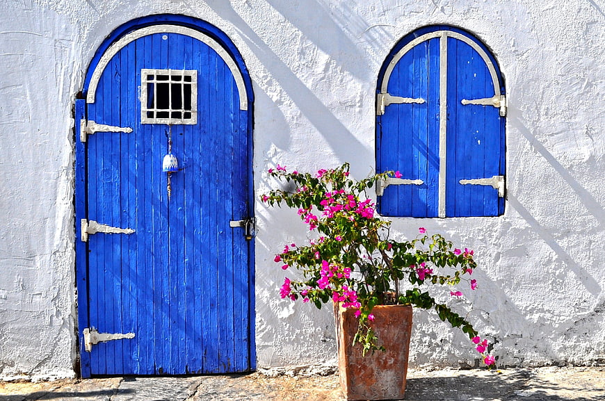 Blue Door and Window on White Wall with Bougainvillea