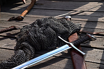 Medieval Weapons and Chainmail Armor on Wooden Deck