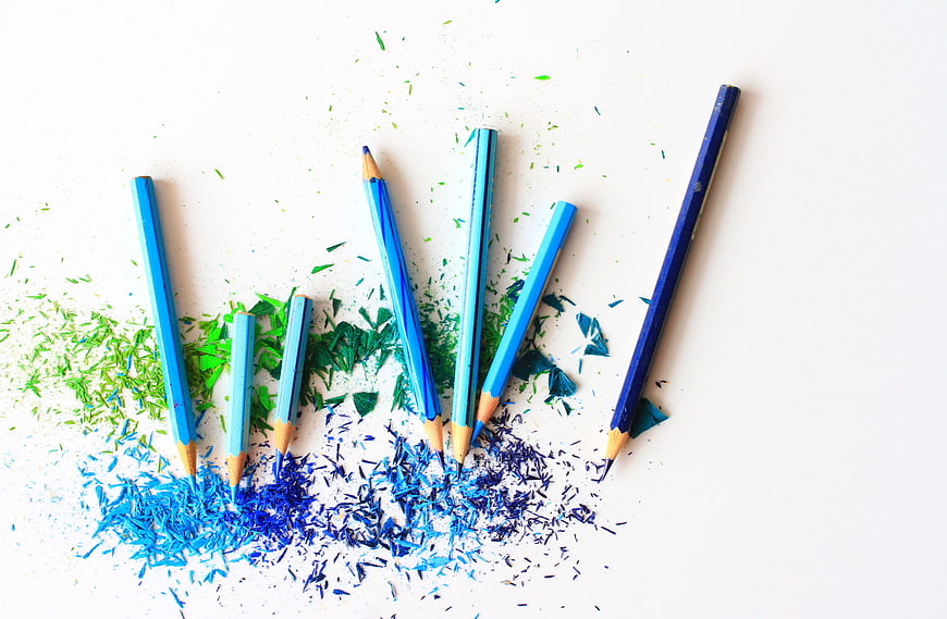 Blue and Green Pencils with Shavings on White Background