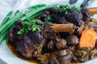 Close-up of braised lamb shanks with mushrooms and carrots