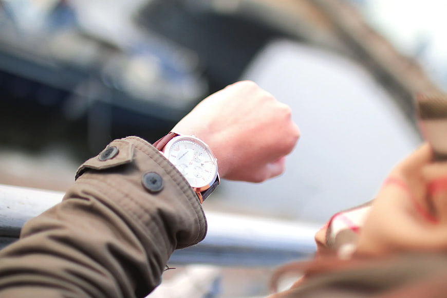 Close-up of woman checking wristwatch outdoors