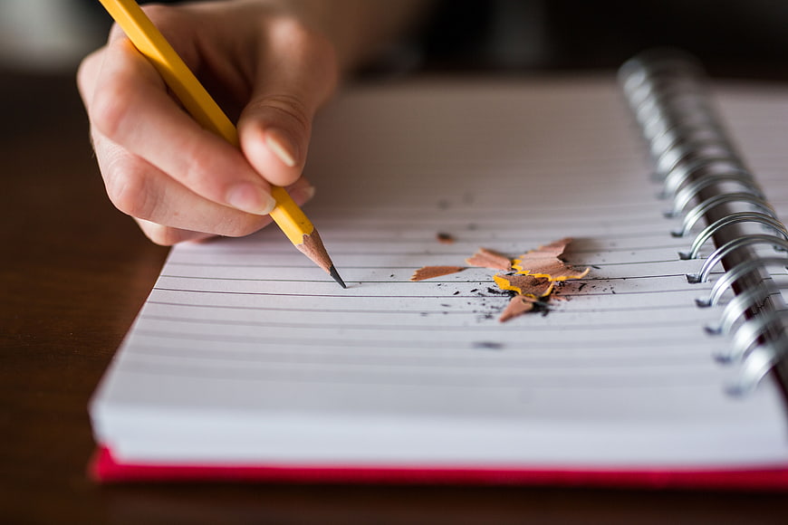 Hand Writing in Notebook with Pencil and Shavings