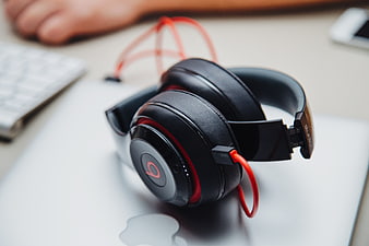 Black and red headphones on a silver laptop