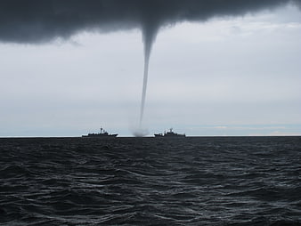 Dramatic Waterspout Over Ocean with Two Warships