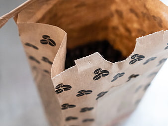Close-up of brown paper bag filled with coffee beans