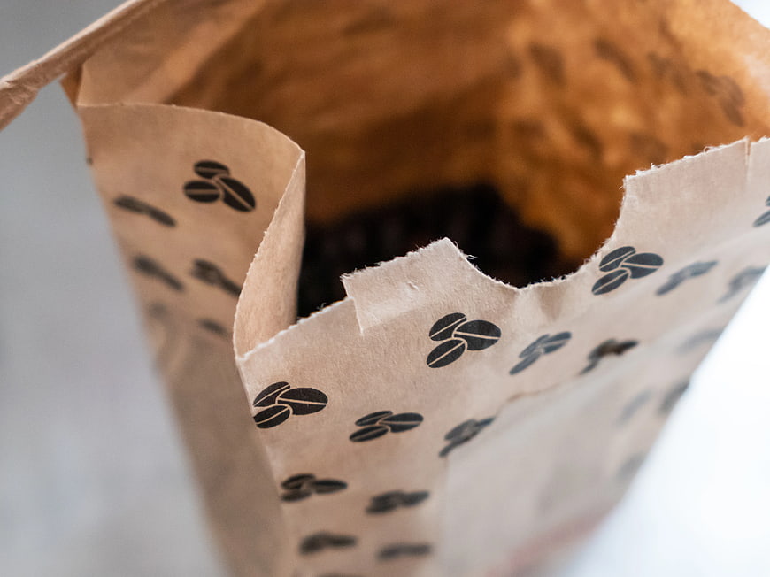 Close-up of brown paper bag filled with coffee beans