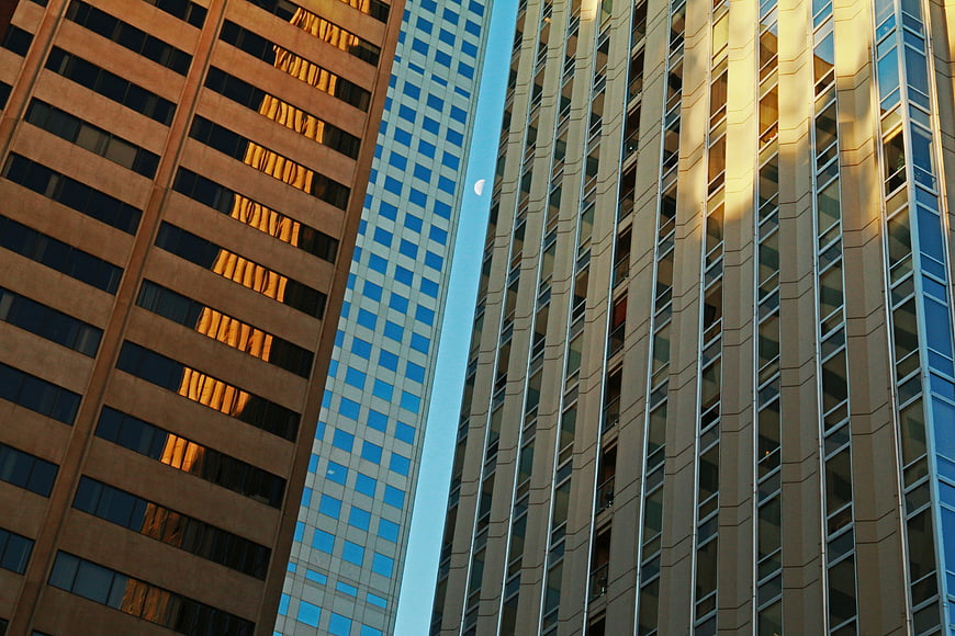 Low angle view of modern skyscrapers with crescent moon