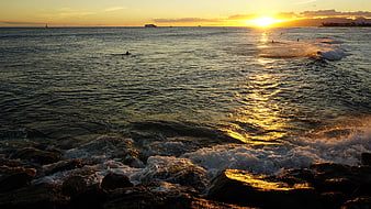 Golden Sunset Over Ocean Waves Crashing on Rocks