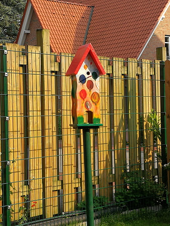 Colorful Hand-Painted Birdhouse On Green Pole In Garden