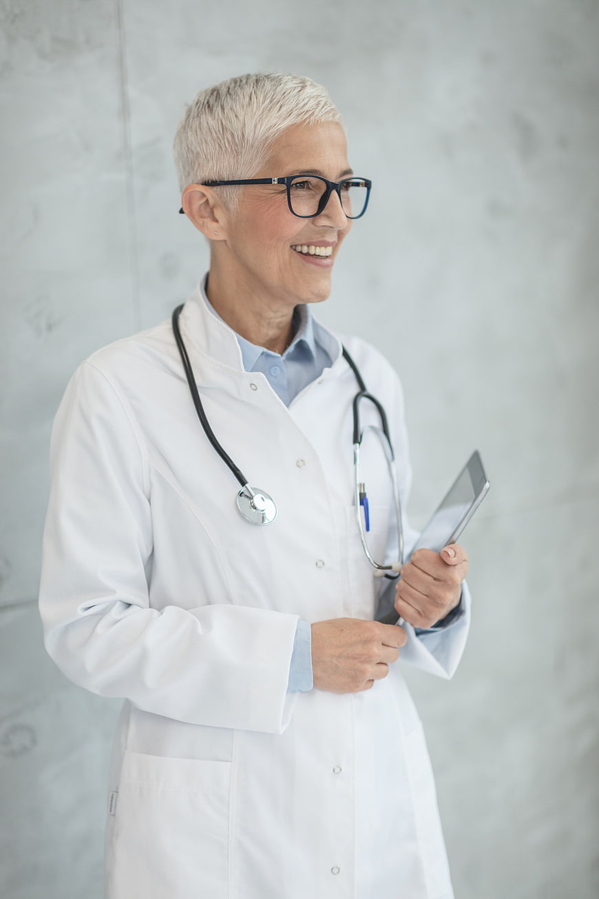 Smiling Senior Female Doctor with Stethoscope and Tablet