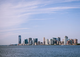 Modern City Skyline Across Blue Water on Sunny Day