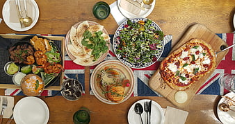 Overhead view of diverse restaurant dishes on wooden table