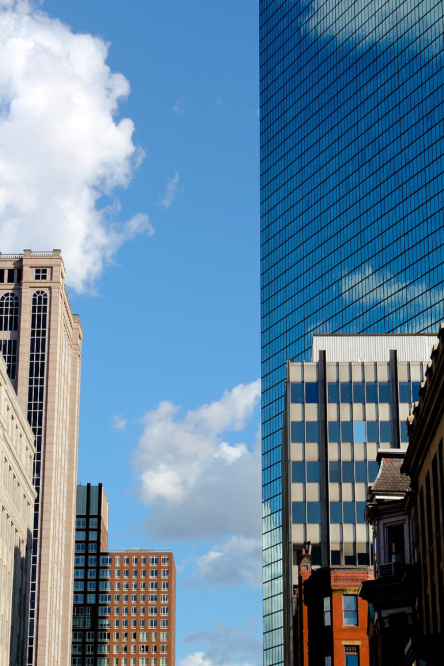 Modern Glass Skyscraper Reflecting Blue Sky and Clouds