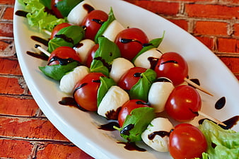 Caprese Skewers with Cherry Tomatoes, Mozzarella, and Basil on White Plate