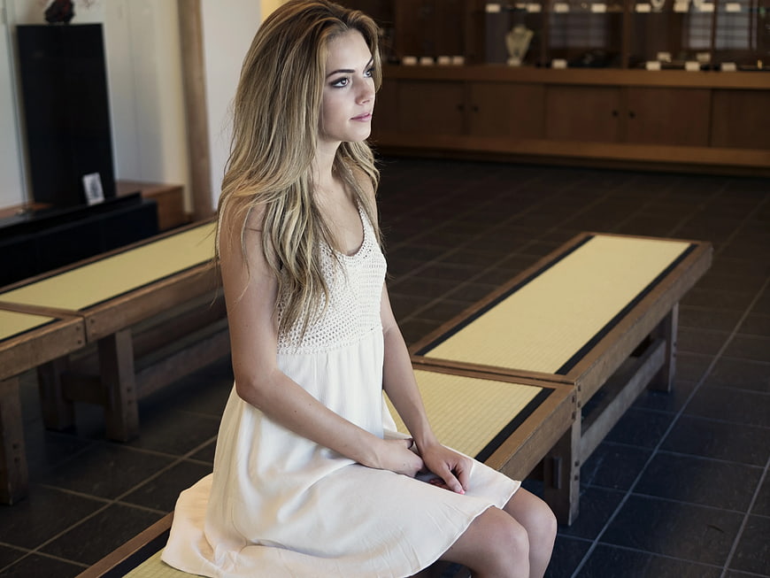Woman in White Dress Sitting on Wooden Bench