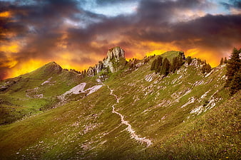 Dramatic Alpine Mountain Landscape With Rocky Peak And Winding Trail At Sunset