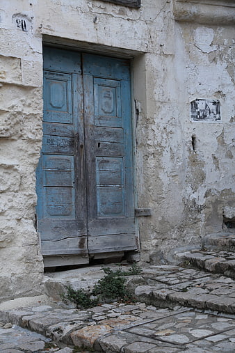 Weathered Blue Wooden Door in Ancient Stone Wall