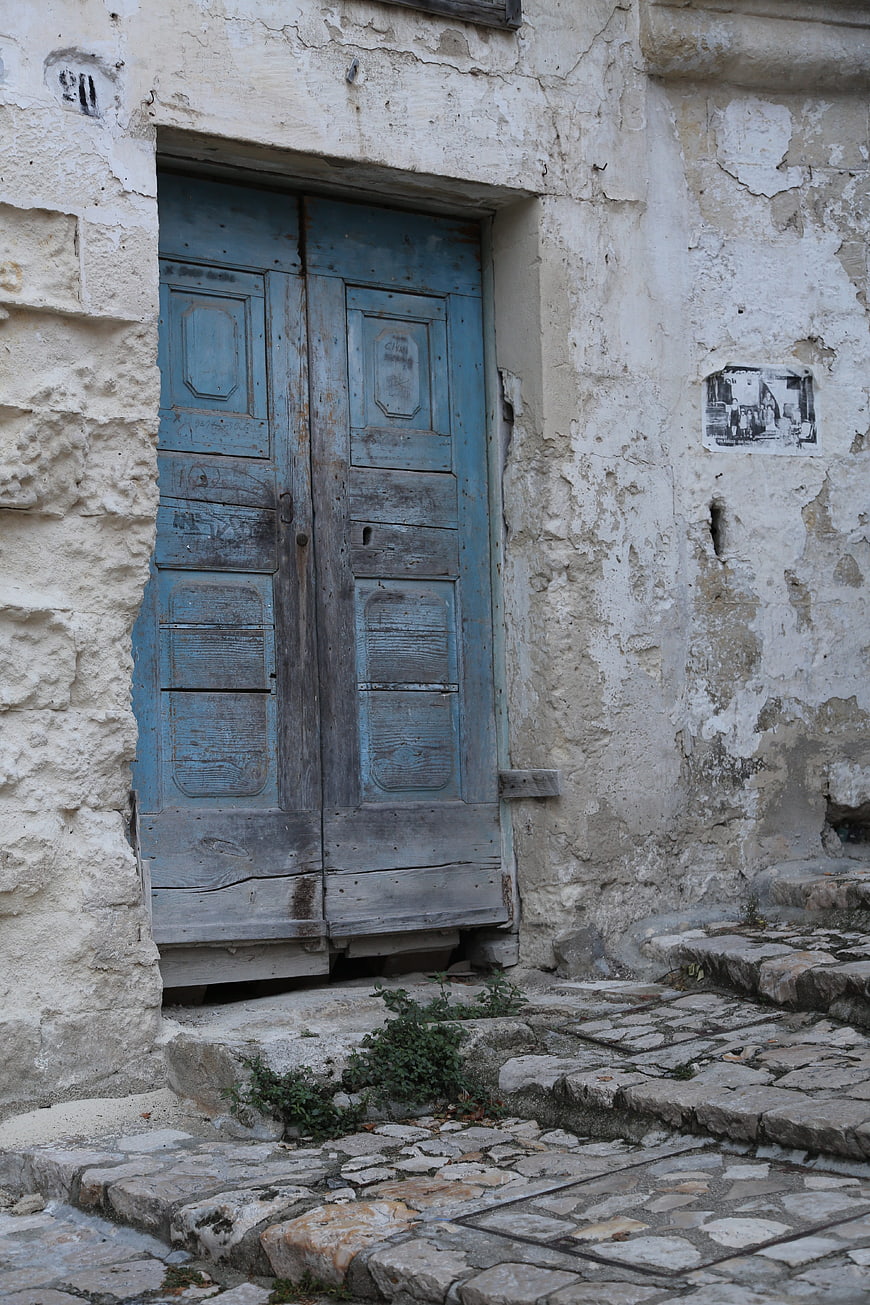 Weathered Blue Wooden Door in Ancient Stone Wall