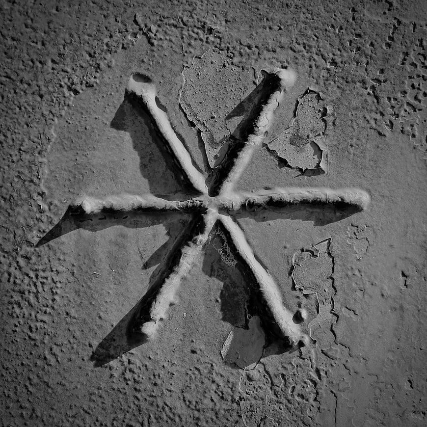Black and white star drawn in sand texture