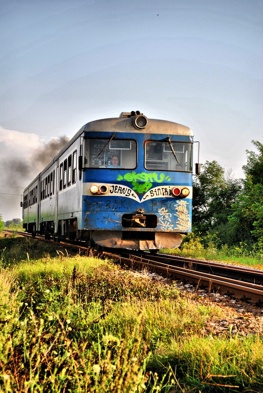 Vintage Blue Diesel Train with Graffiti on Rural Tracks