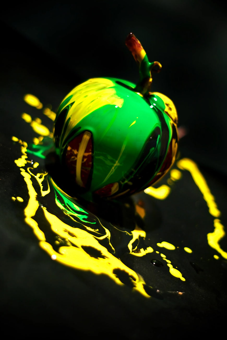 Abstract Green and Yellow Painted Apple on Black Background