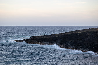 Rugged Rocky Coastline with Crashing Ocean Waves at Dusk