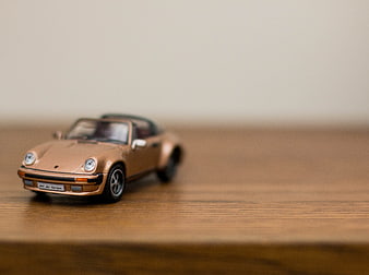 Gold Porsche 911 SC Targa Model Car on Wooden Surface