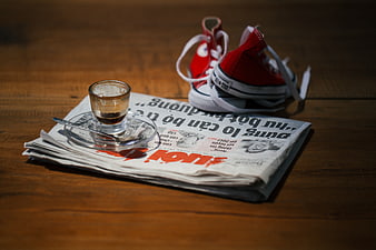 Red sneakers and coffee on newspaper