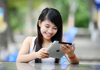 Happy Asian Woman Using Tablet Outdoors