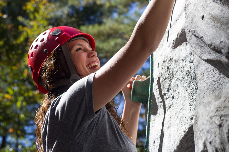 Happy Woman Rock Climbing On Outdoor Wall