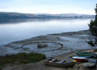 Stone circle on lake shore with rowboats