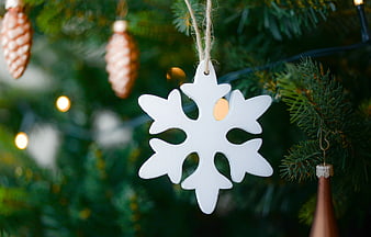 White Snowflake Ornament on Christmas Tree with Bokeh Lights