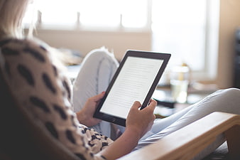 Woman Reading E-Book on Tablet in Cozy Living Room