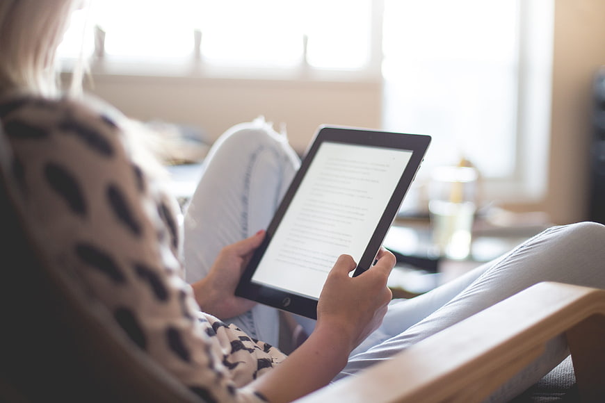 Woman Reading E-Book on Tablet in Cozy Living Room