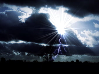 Dramatic lightning bolt striking through dark storm clouds