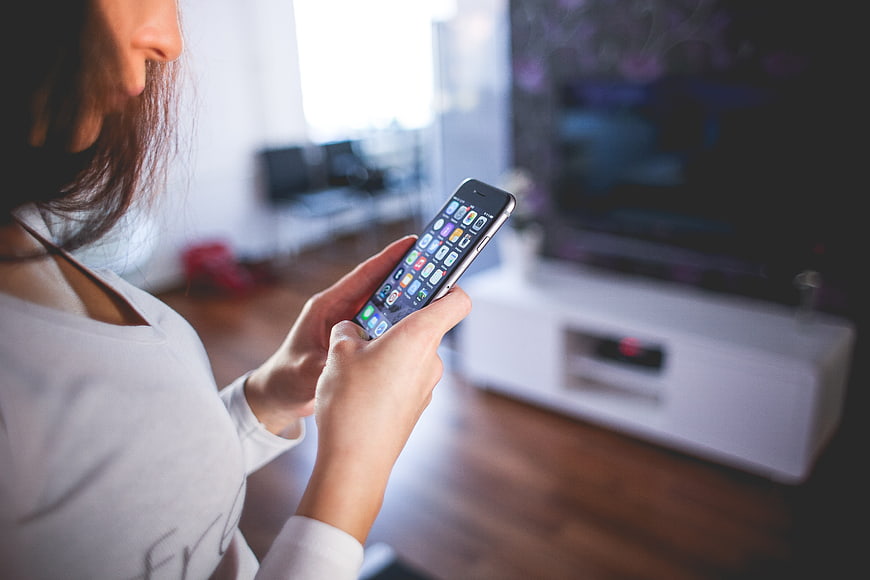 Woman using smartphone in modern living room interior