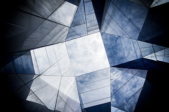 Low angle view of modern glass skyscraper reflecting clouds