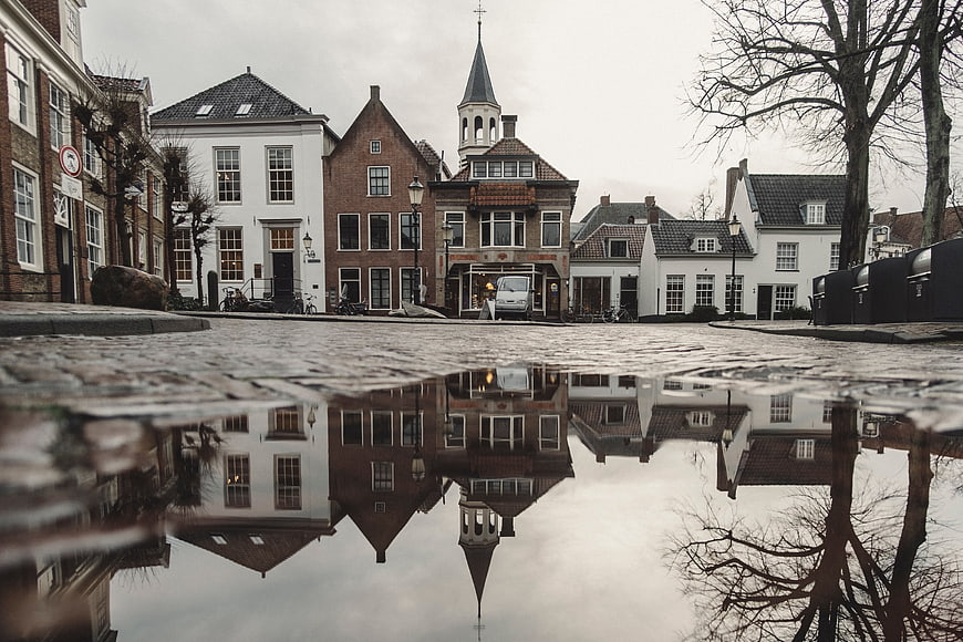 Low angle reflection of Dutch canal houses in puddle