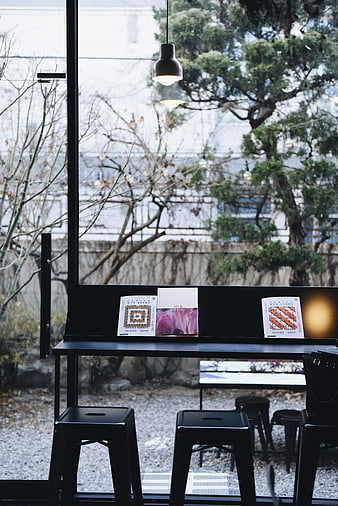 Minimalist black cafe interior with vinyl records and window view