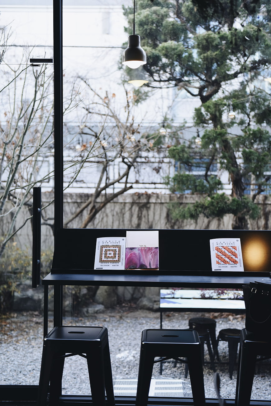 Minimalist black cafe interior with vinyl records and window view