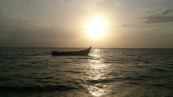 Silhouette of a fishing boat on the ocean at sunset