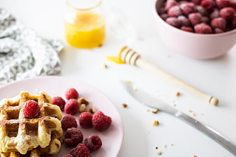 Delicious Waffles with Raspberries and Honey on Pink Plate