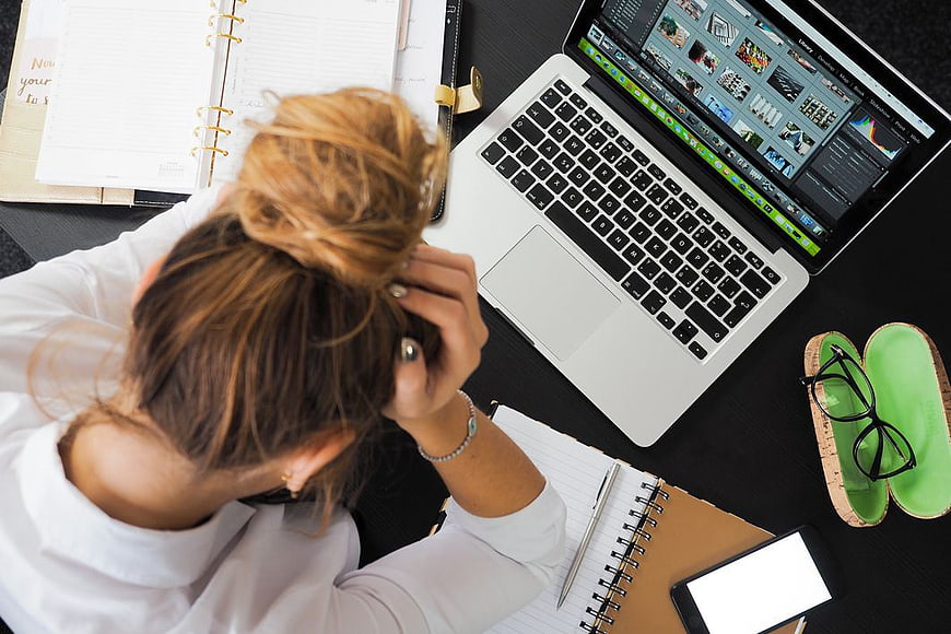 Overhead view of stressed businesswoman at desk