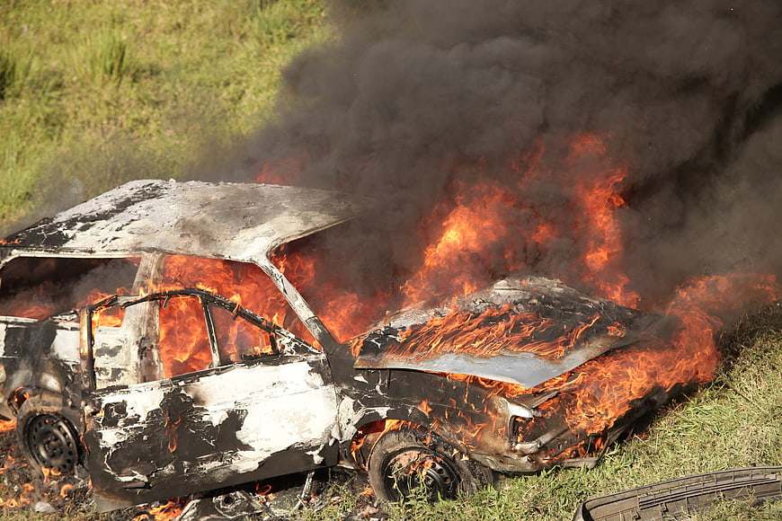 Burnt Car Wreck Enveloped in Flames and Smoke
