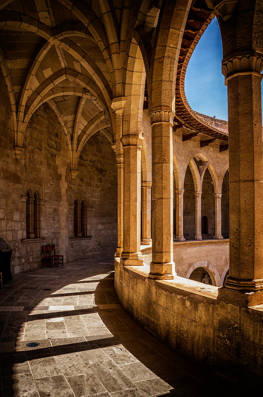 Sunlit Gothic Cloister Arches and Stone Pillars
