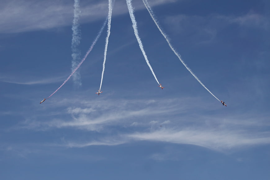 Four aerobatic jets flying in formation with smoke trails