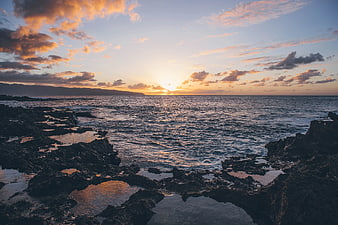 Dramatic Sunset Over Rocky Ocean Coastline
